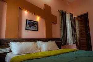 a bedroom with a large bed with white pillows at Aikara cottages in Vagamon