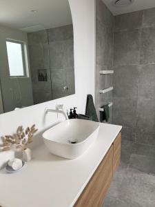 a bathroom with a white sink and a mirror at McNeil Luxury Studio in Wanaka