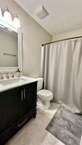 a bathroom with a toilet and a sink and a mirror at 2200SQFT Coastal home on half Acre in Jacksonville +13 photos