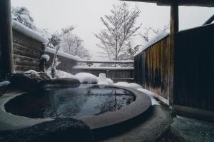 a pool of water with snow on top of it at 旅館 焼乃湯 in Takayama +119 photos