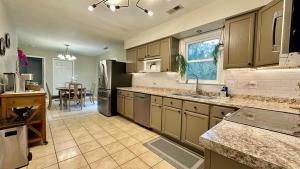 a large kitchen with a refrigerator and a table at 2200SQFT Coastal home on half Acre in Jacksonville