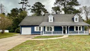a blue house with a porch and a driveway at 2200SQFT Coastal home on half Acre in Jacksonville