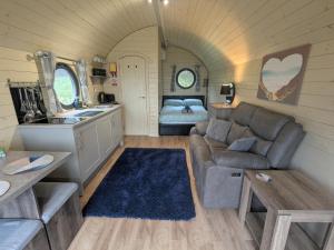 a living room with a couch and a bed at Stapeley Pod in Shrewsbury