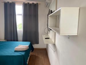 a small room with a bed and a window at Flats da Júnia - ótimo beneficio com wifi, ar, tv, frigobar in Lagoa Santa