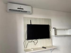 a flat screen tv hanging on a wall at Flats da Júnia - ótimo beneficio com wifi, ar, tv, frigobar in Lagoa Santa