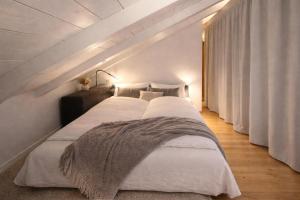 a bedroom with a large bed in a room with white walls at ChiemseeRefugium - Ferienwohnung Park in Bernau am Chiemsee