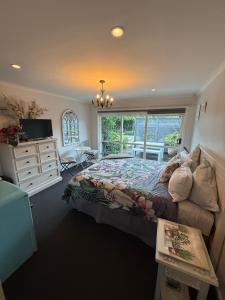 a bedroom with a bed and a dresser and a window at Waitomo Orchard Estate B&B in Otorohanga