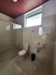 a bathroom with a toilet and a shower and a sink at Hotel Campestre El Alcazar in Moniquirá