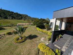 a house with a palm tree in the yard at Hotel Campestre El Alcazar in Moniquirá