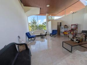 a living room with blue chairs and a couch at Hotel Campestre El Alcazar in Moniquirá