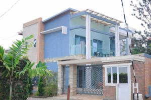 a blue house with a balcony on top of it at Faraja Guest House in Kigali