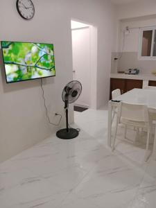 a white living room with a fan and a table at Jannish Transient House in Masbate