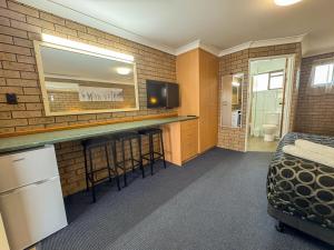 a room with a bar with a television and a bed at Macintyre Motor Inn in Goondiwindi
