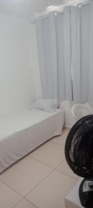 a white room with a bed and a window at Casa condomínio in Maceió