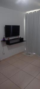 a living room with a flat screen tv on a wall at Casa condomínio in Maceió