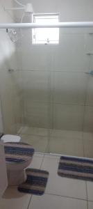 a bathroom with a glass shower with a toilet at Casa condomínio in Maceió