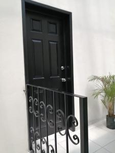 a black door with a wrought iron railing at VENECIA APARTMENT, Excellent Location in Tepic +4 photos
