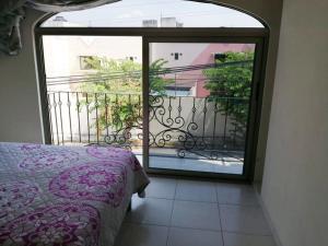 a bedroom with an open door to a balcony at VENECIA APARTMENT, Excellent Location in Tepic