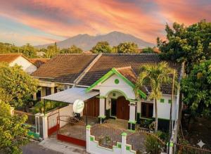 a white house with a mountain in the background at Griyaponcowolo Syariah Full Furnished Family Home in Central Jogja in Yogyakarta