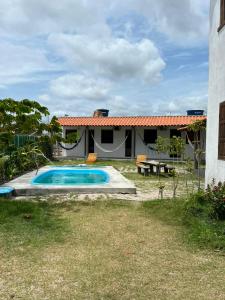 a backyard with a swimming pool and a house at Suite Adam 3 em Caraíva com piscina 900m da Vila in Caraíva