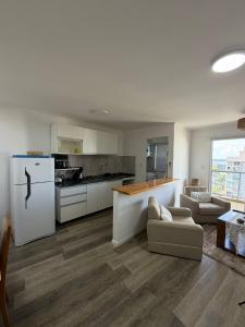 a kitchen with a white refrigerator and a table at Torre Aymara 8C in Posadas