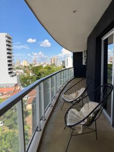 two chairs on a balcony with a view of the city at Torre Aymara 8C in Posadas