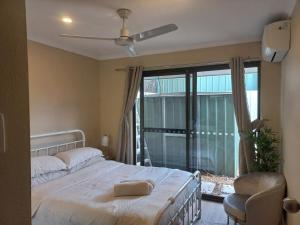a bedroom with a bed and a large window at Peaceful and private two bedroom unit in Alice Springs
