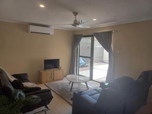 a living room with a couch and a tv at Peaceful and private two bedroom unit in Alice Springs