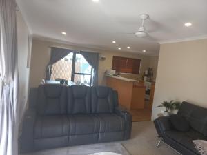 a living room with a couch and a kitchen at Peaceful and private two bedroom unit in Alice Springs