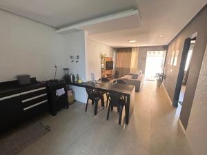 a kitchen and living room with a table and chairs at Búzios Family House in Búzios