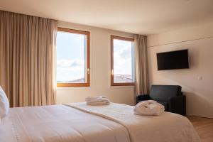 a hotel room with a bed and a chair at Foz Côa Story House in Vila Nova de Foz Coa +37 photos
