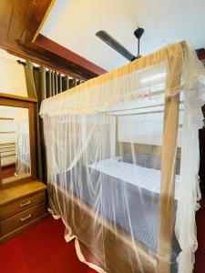 a bed covered in mosquito nets in a room at Madu Villa in Weligama
