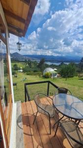a patio with a table and chairs and a view of a field at Glamping La Villa in Guatavita