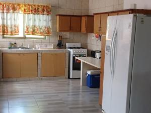 a kitchen with a white refrigerator and a sink at Sunny Isle Apartment in Rooi Master +20 photos