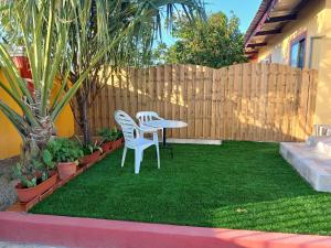 a patio with a table and two chairs on the grass at Sunny Isle Apartment in Rooi Master