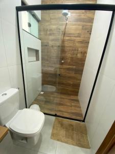 a bathroom with a toilet and a shower at Casa da Cle, 2 quartos com ar condicionado, 600m da praia in Itapoa
