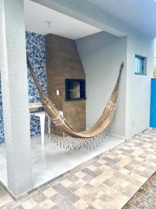 a large brown hammock hanging on a wall at Casa da Cle, 2 quartos com ar condicionado, 600m da praia in Itapoa +11 photos