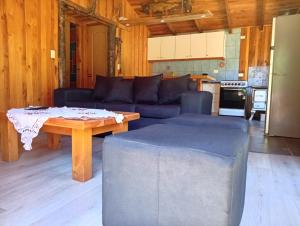 a living room with a couch and a table at Cabaña borde rio in Pucón