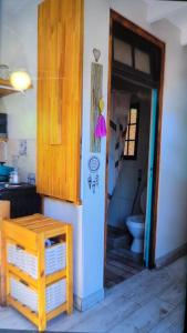a bathroom with a toilet and a door to a room at Piccolo Casa de playa La caleta in Mar de Cobo