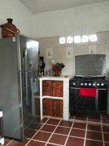 a kitchen with a stove and a refrigerator at Casa HecAny in Catemaco +13 photos