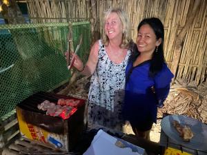 two women standing next to each other holding chopsticks at Island Crib in El Nido