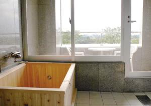 a bathroom with a tub and a window and a sink at PrincessPrincessAzumino in Azumino