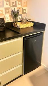 a black dishwasher under a counter in a kitchen at Pousada Studio Siriú in Garopaba +21 photos