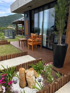 a wooden deck with a bench and a potted plant at Pousada Studio Siriú in Garopaba