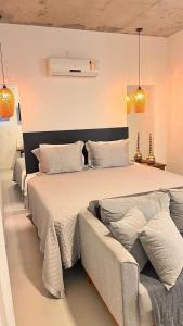 a bedroom with a large bed and a couch at Pousada Studio Siriú in Garopaba