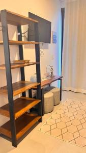 a living room with a book shelf and a tv at Pousada Studio Siriú in Garopaba