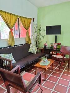 a living room with a couch and a tv at Casa HecAny in Catemaco