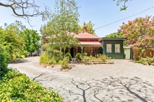 a house with a gravel driveway in front of it at Winery Cottage in Tanunda