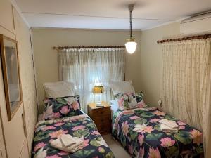 a bedroom with two beds and a table with a lamp at Winery Cottage in Tanunda