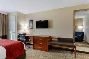 a hotel room with a bed and a desk and a mirror at Springplace Inn & Suites in Marion